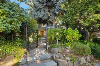 From the sidewalk, the front gate offer a peek-a-boo view of the front door.