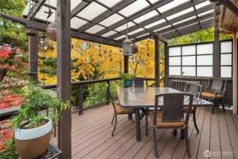 Low-maintenance composite deck with covered arbor, privacy screens, wired temple lanterns, and rain chains.
