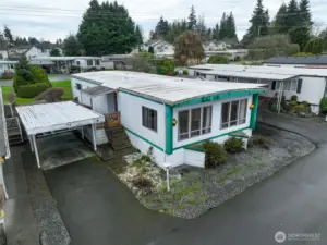 Home #24 with covered carport, plus additional driveway parking.  One more parking space behind back deck and storage shed is beyond the carport.