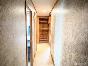 Main bath doorway and linen closet door on the left side of the hallway.