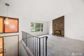 Spacious living room with vaulted ceiling and cozy wood fireplace.