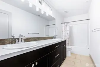 Full size bathroom located upstairs offers wide/modern tile flooring, a dual vanity with plenty of cabinet storage and a full shower/bath combo. The large mirror and no shortage of lighting makes it easy to get freshen up