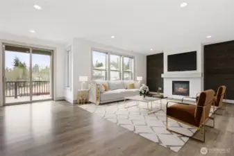 Large Family room offers plenty of space for entertaining.  Hidden cable outlets within the rustic stained wood backdrop for a clean design.  Large windows and a cozy fireplace sets the ambiance