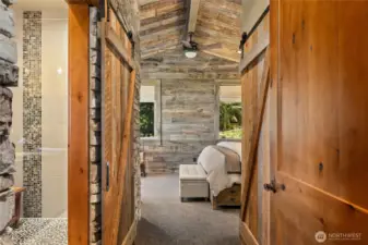 Custom reclaimed pine millwork and striking stonework set the tone as you enter the primary suite.