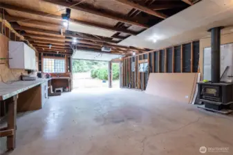 Interior of the large shop with electric garage opener.  The shop also has a very tall additional enclosure for RV storage.  There is also drop down access for attic storage.  This is a very deep shop.