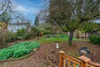 Lush landscaping blankets the yard with native plantings and garden beds.