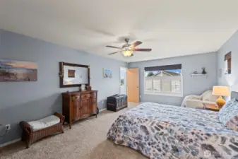 The primary suite has shutters on the large window and bamboo shades on two small windows that flank the bed. It’s spacious!