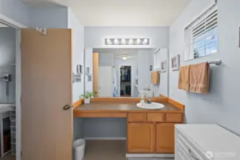 Primary bathroom vanity with space to add a double vanity or leave it as-is for convenient laundry storage.