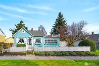 Storybook charm meets timeless character in this beautifully maintained cottage featuring vibrant curb appeal, classic white picket fencing, and inviting garden landscaping.