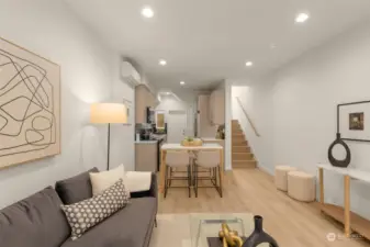 Experience the seamless connection between the living space and kitchen, enhanced by a modern staircase that leads to private quarters above.