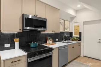 Sophisticated black tile backsplash, stainless steel appliances, and custom cabinetry create a sleek and functional kitchen space. It's a modern chef's paradise that combines style with convenience.