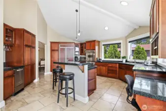 Bar seating and a wet bar with sink and ice machine to the left.