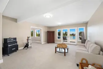Large family room with second primary bedroom suite to the left and access to lower view deck and hot tub.