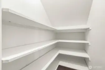 Walk-in pantry provides ample shelving for easy organization.