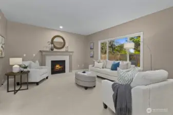 Cozy great room with gas fireplace and large window overlooking the backyard.