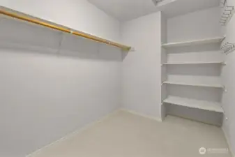 Walk-in closet with built-in shelving and plenty of storage.