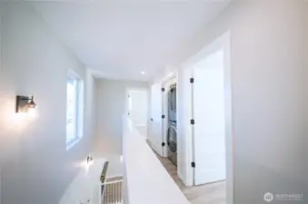 Upstairs hallway is open and bright with laundry closet and upgraded washer and dryer.