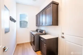 Laundry area offers a mudroom option for coats and shoes at the garage entry.