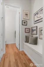 Convenient built-in bench off entrance, adjacent to powder room and coat closet, provides the perfect spot to remove shoes and coats