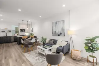 Sun-filled living room with wide plank floors and oversized windows that showcase the energy of the neighborhood while filling the interior with natural light.