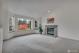 Living room with bay window.  Cozy up to the fireplace.  Perfect place for gatherings.
