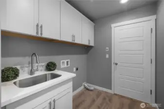 Utility sink next to the washer and dryer hook ups.