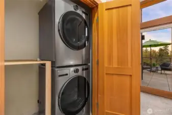 Full sized stacked washer and dryer in the upper level closet.