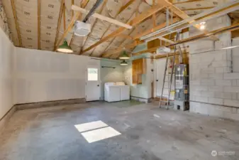 Two car garage and utility area with lots of room for storage. Brand new insulation, drywall, water heater, washer/dryer, and more vintage lights.