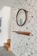 Entry with stylish hexagon tile and hardwood stairs leading to the second level.