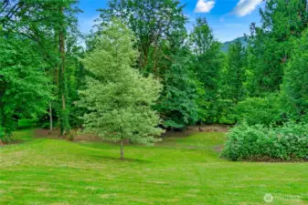 The grounds are truly beautiful—lush, green, and thoughtfully designed to highlight the natural surroundings. A mix of open lawn and mature trees creates a peaceful, park-like setting, while a cozy clearing with benches and a fire pit invites quiet gatherings or evening stargazing. It’s a serene retreat that feels both expansive and intimate, perfect for anyone who loves nature and outdoor living.