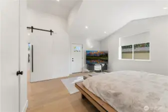 Primary bedroom. Door to private covered deck to the right in the background. Sliding barn door to the left goes to the bathroom.