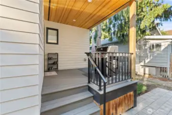 Covered deck right off the kitchen. A few extra touches you might not notice at first glance: cedar ceiling above, gas plumbing for the BBQ, to the right below the railing is a custom door to access under the porch storage.