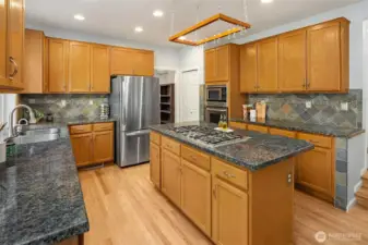 Kitchen with granite countertops, ample cabinet storage and pantry