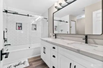 A spectacular Primary Bath with a new, larger tub, tile surround shower, new lighting, mirror and shower head.  A second sink was added, new cabinets and Calcutta Creek countertops.