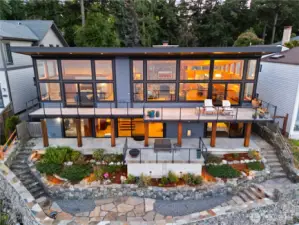 View of the home from the waterside showing the incredible amount of glass designed to absorb the warm sun and stunning views.