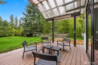 The home is set on a .72 acre lot. The back deck has views across the lawn to a cove of evergreens.