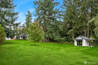 Expansive lawn, evergreens and a small heated studio.