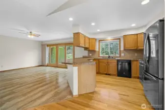 Open kitchen with peninsula seating flowing into the family room with sliding door access to the backyard.