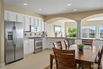 Full kitchen with architecturally pleasing arches capture the view from the generational kitchen and dining