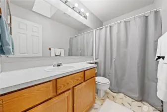 Upstairs full sized guest bathroom with tub/shower combo with a skylight that brings in lots of natural light.