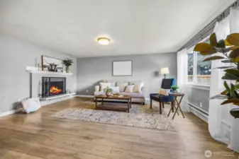 Bright, open living room featuring a wood burning fireplace.