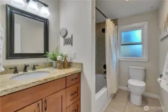 Upstairs full bathroom has granite counters and a tiled shower.