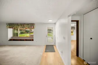 Front door into living room. Primary bedroom to the right.