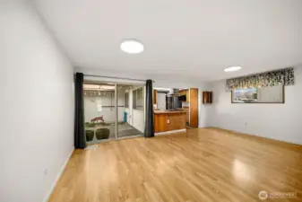 Dining room area, looking out towards the patio, with the kitchen to the right.