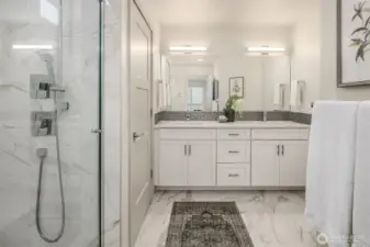 Primary bath with vanity with double sinks, large walk in shower and separate W/C.