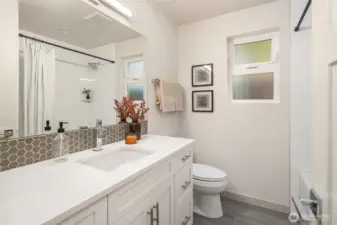 Main floor full bath with deep soaking tub and large vanity.
