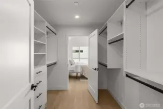 Generous walk-in closet with built-in shelving, providing ample organization and storage space.