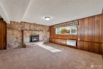 Large family room with floor to ceiling stone fireplace with insert