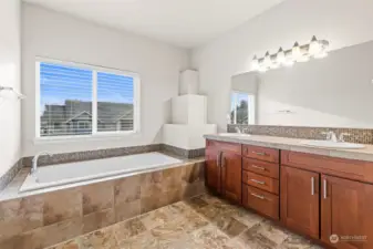 Primary bedroom ensuite bath with large tub and dual vanity sink.