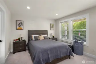 Primary bedroom with private deck with views of Puget Park and walk-in closets and en suite.